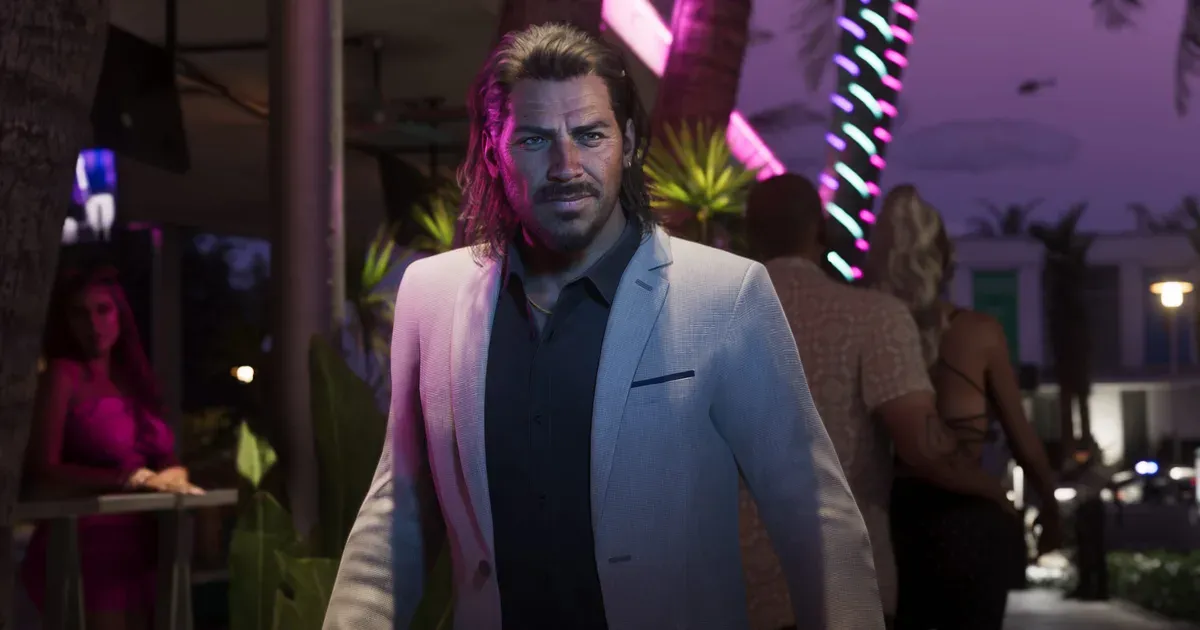 Raul Bautista caminando por una calle de vida nocturna de Vice City iluminada de neón durante la noche en GTA 6, el personaje que Rockstar describe como un atracador de bancos que recluta un equipo